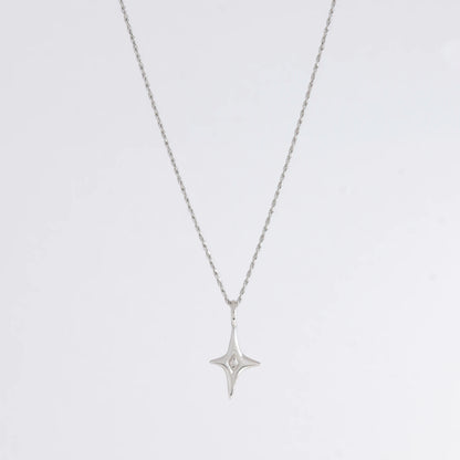 Silver star-shaped pendant necklace on a light gray background