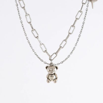 Silver chain necklace with a teddy bear pendant on a white background