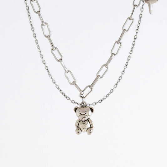 Silver chain necklace with a teddy bear pendant on a white background