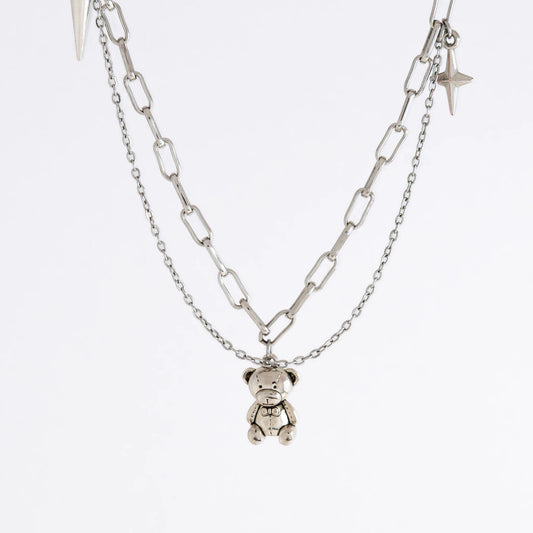 Silver chain necklace with a teddy bear pendant on a white background