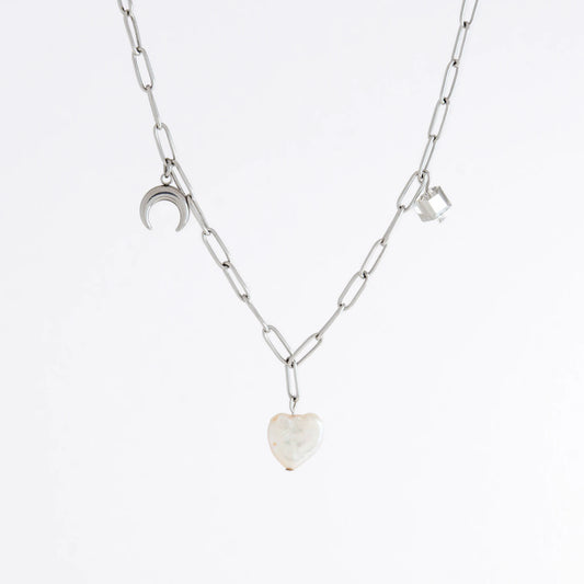Silver chain charm necklace with pearl pendants, glass bead, and star pendants on a light gray background