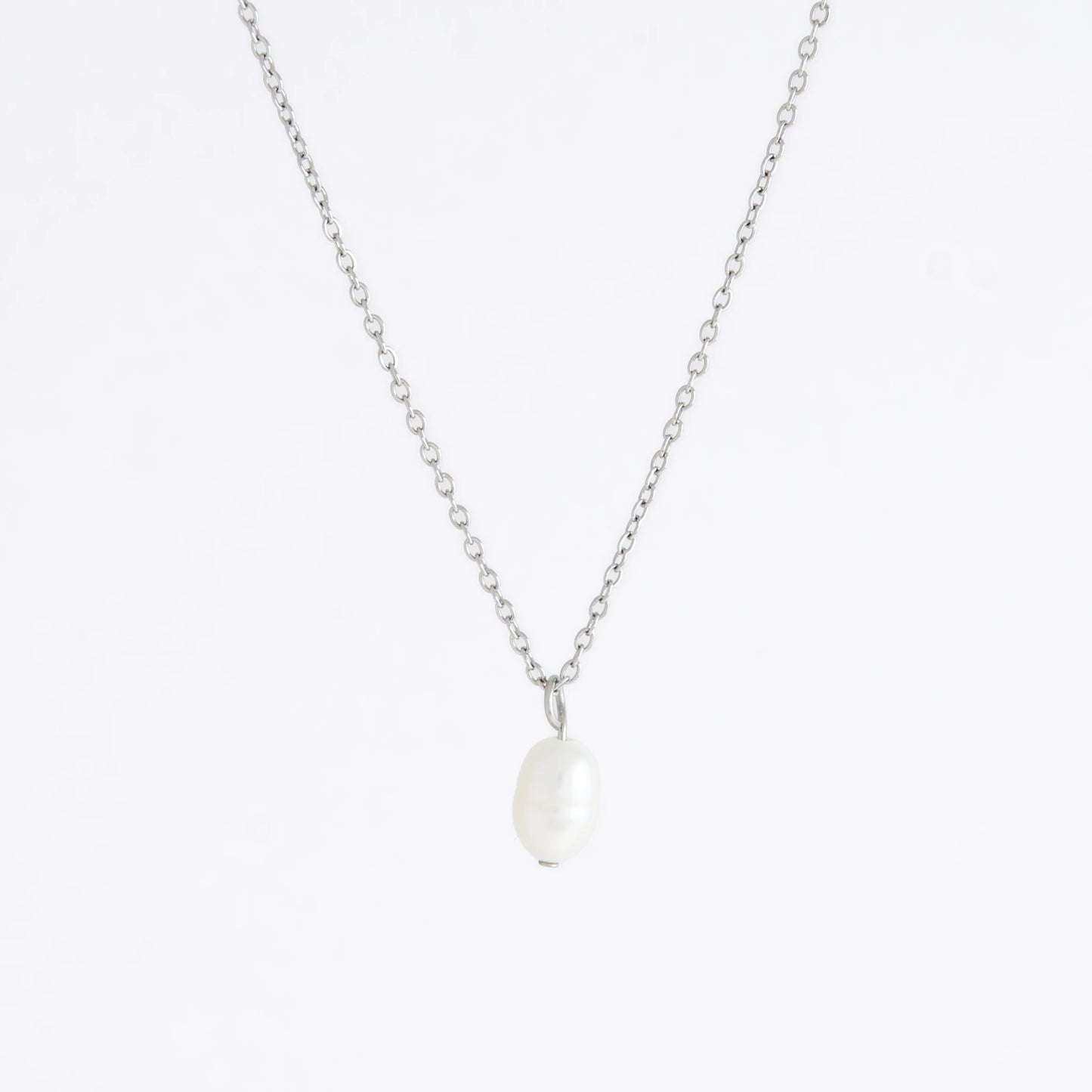 Silver dainty pearl necklace with freshwater pearl charm on a light gray background