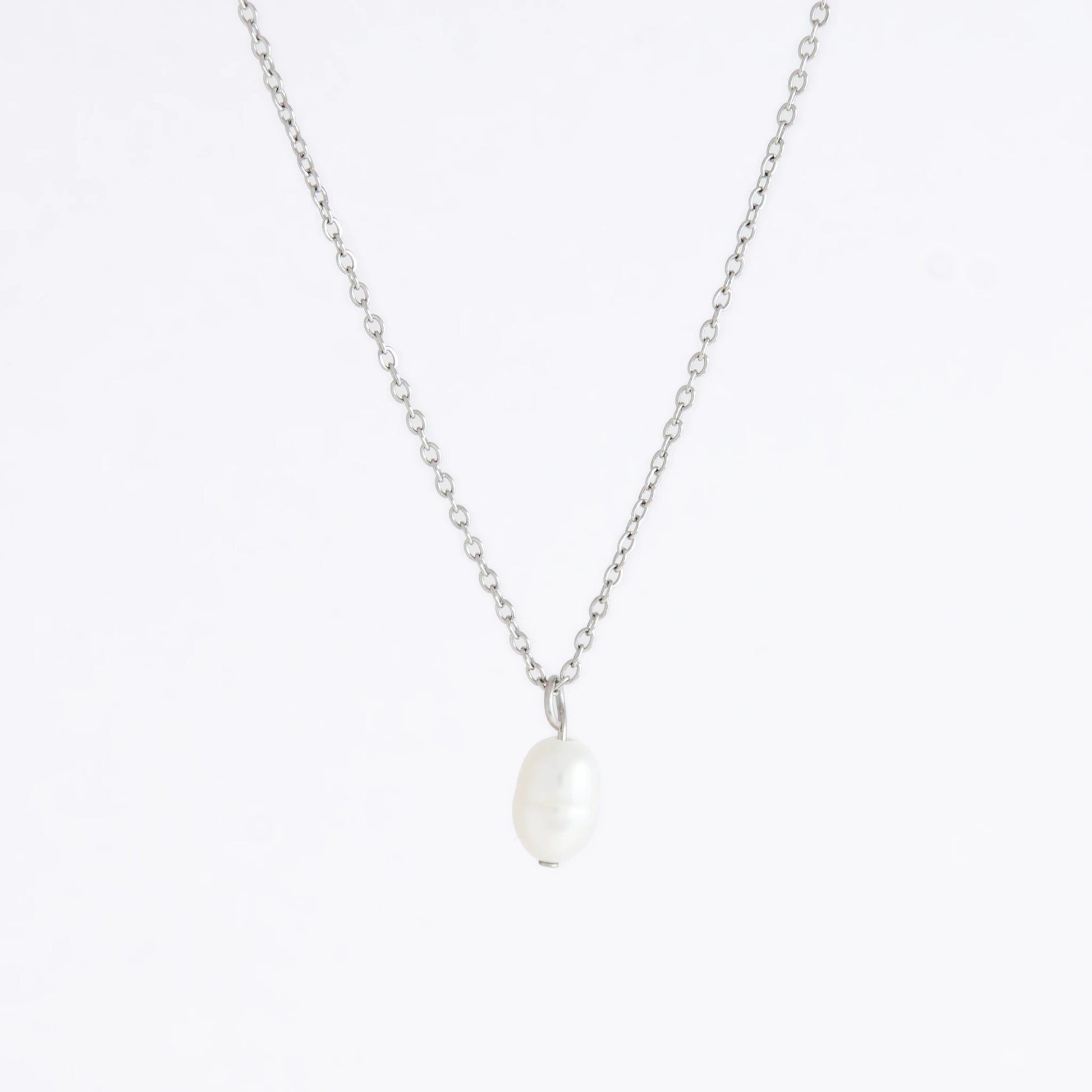 Silver dainty pearl necklace with freshwater pearl charm on a light gray background