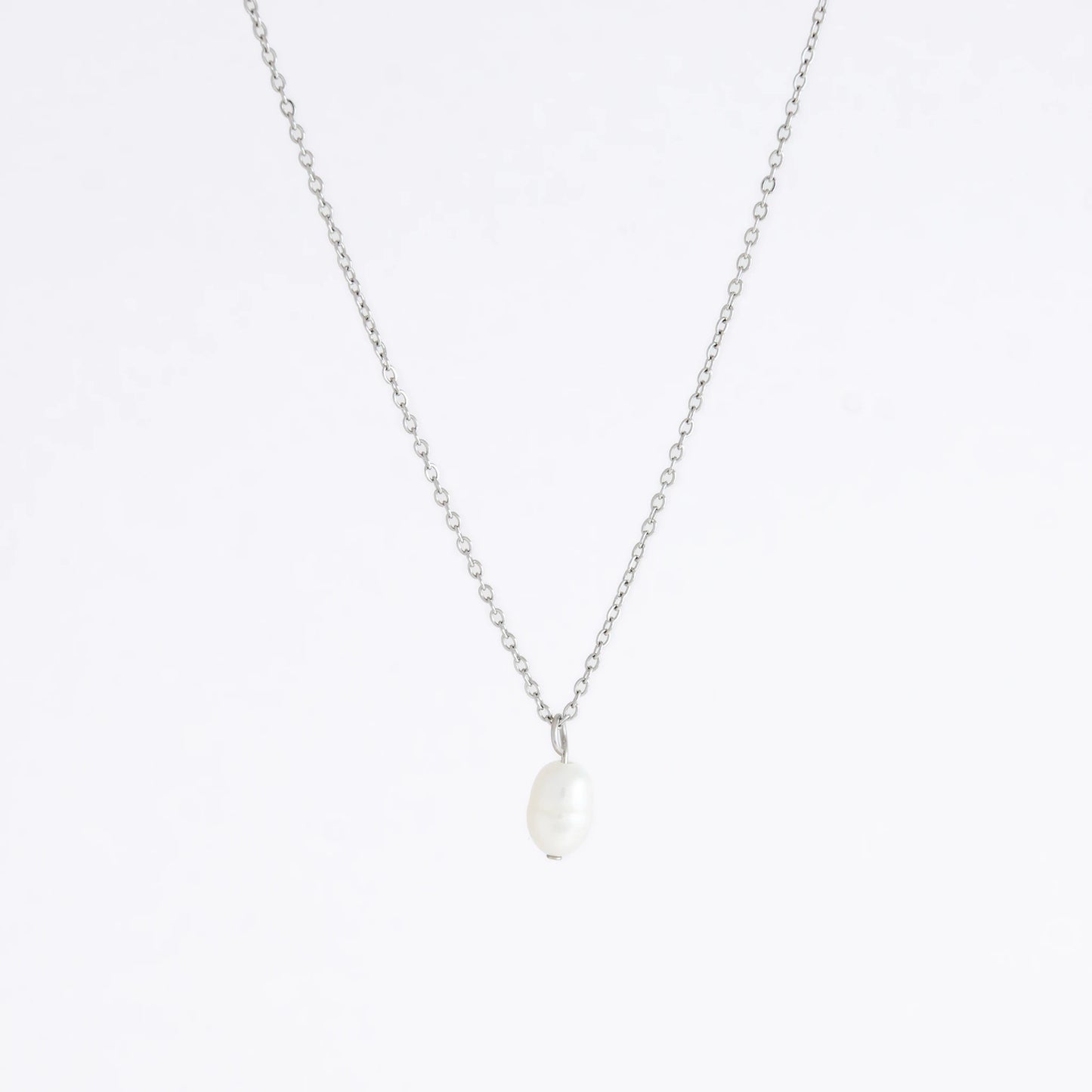 Silver dainty pearl necklace with freshwater pearl charm on a light gray background