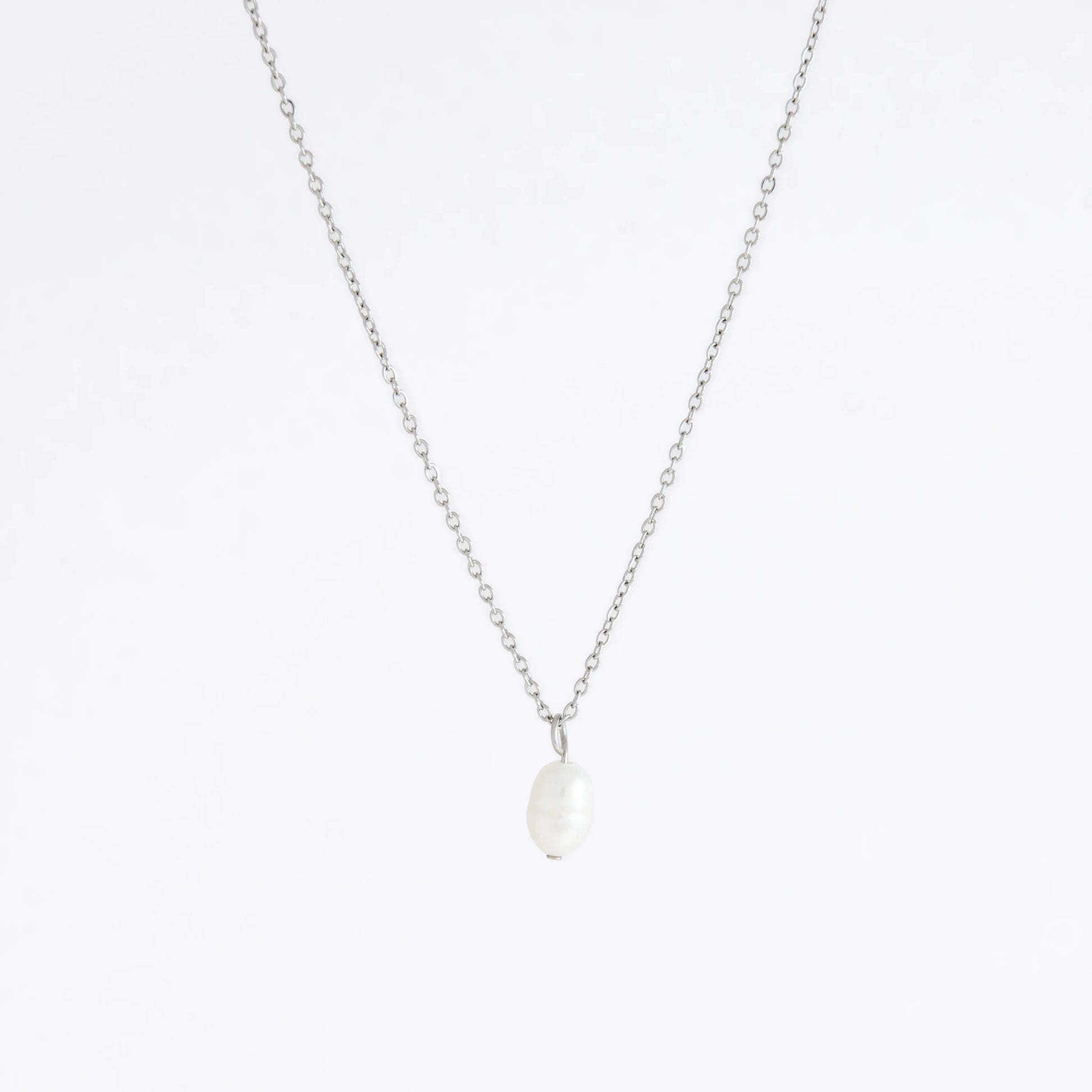 Silver dainty pearl necklace with freshwater pearl charm on a light gray background