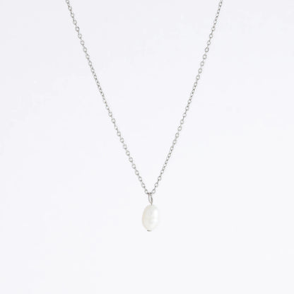 Silver dainty pearl necklace with freshwater pearl charm on a light gray background