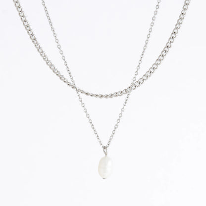 Silver stainless steel layered necklace set with a curb chain and a dainty pearl pendant necklace on a light gray background