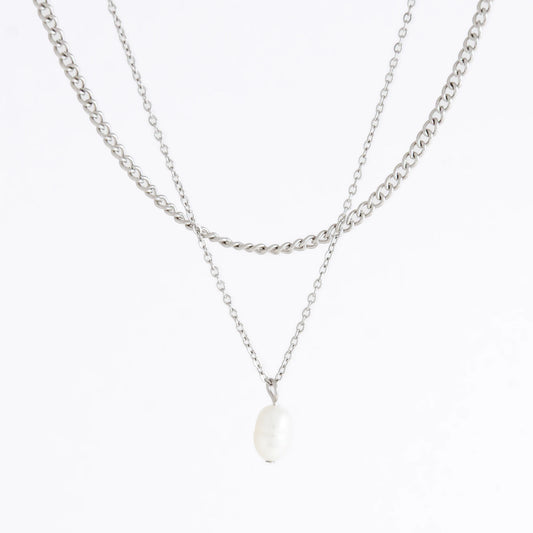 Silver stainless steel layered necklace set with a curb chain and a dainty pearl pendant necklace on a light gray background