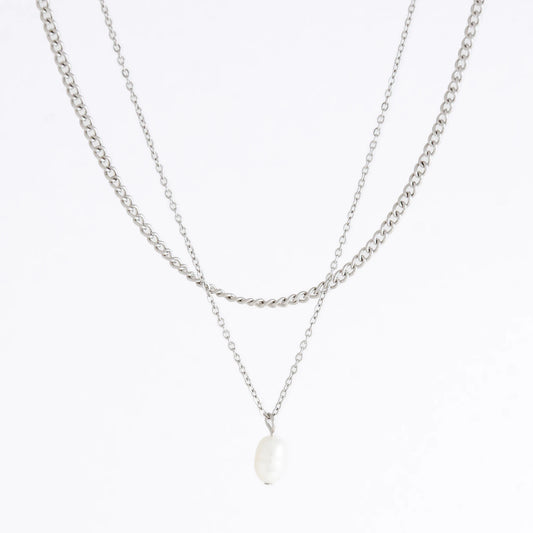 Silver stainless steel layered necklace set with a curb chain and a dainty pearl pendant necklace on a light gray background