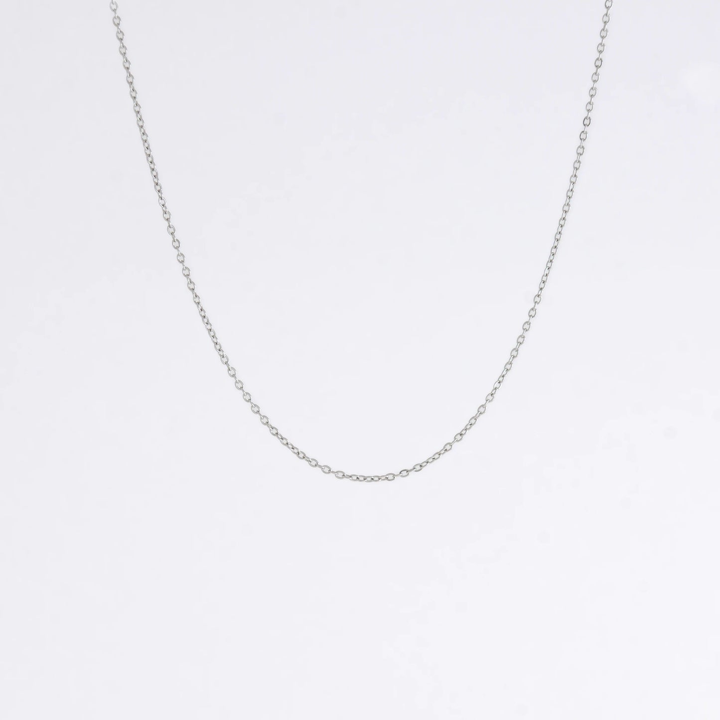 Silver stainless steel dainty chain necklace on a light gray background