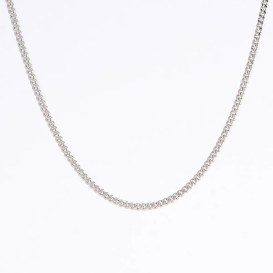 Silver curb chain necklace on a light gray background
