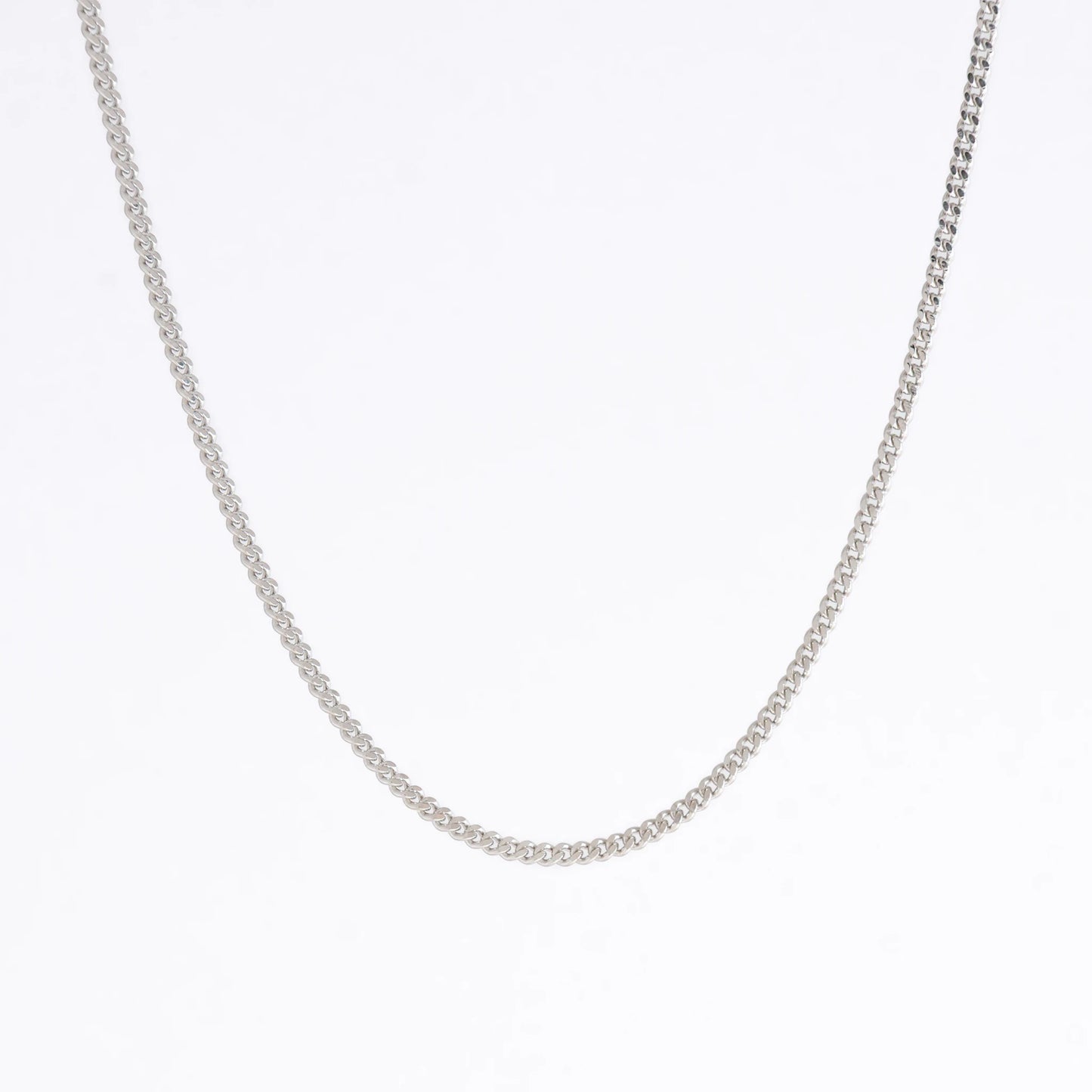 Silver curb chain necklace on a light gray background