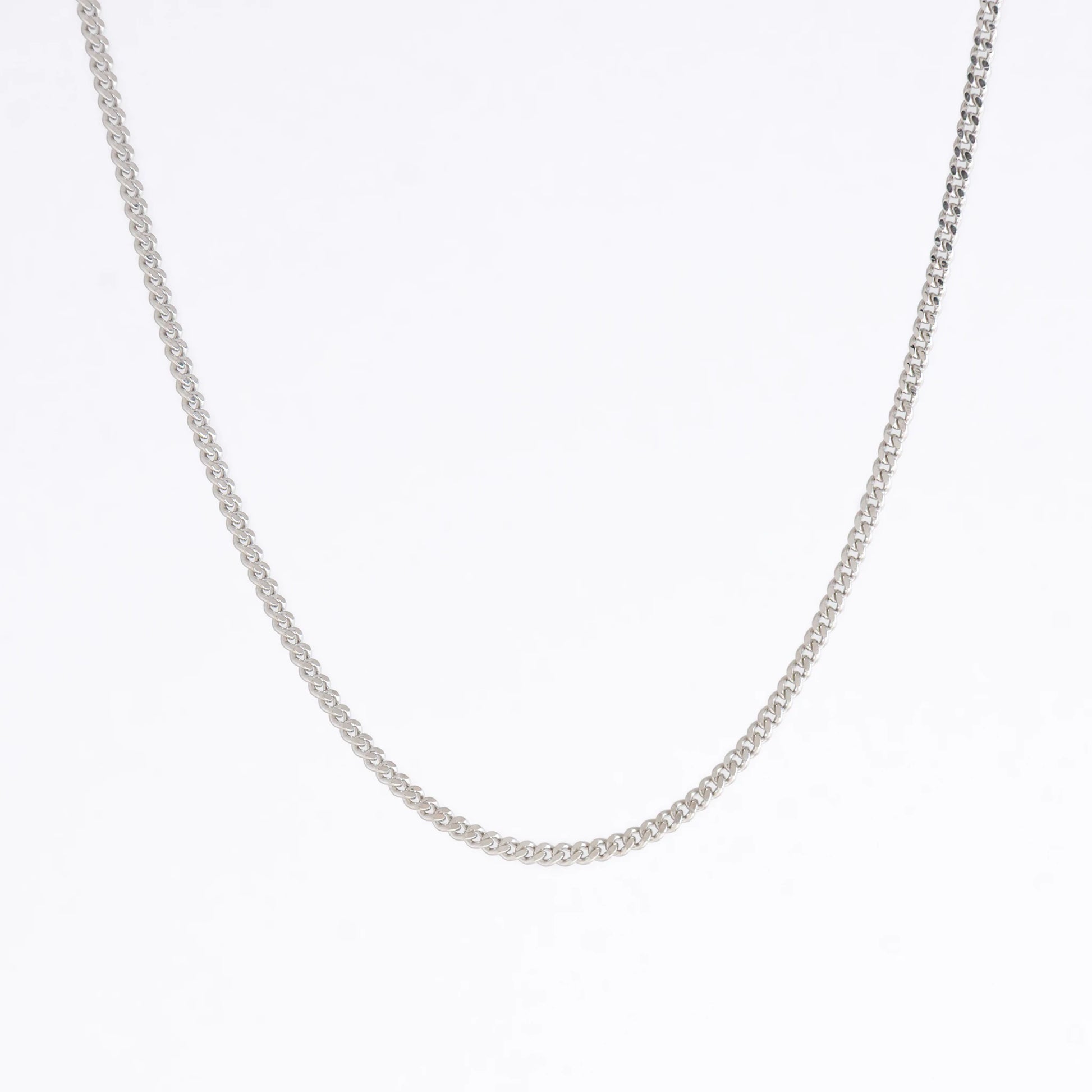 Silver curb chain necklace on a light gray background