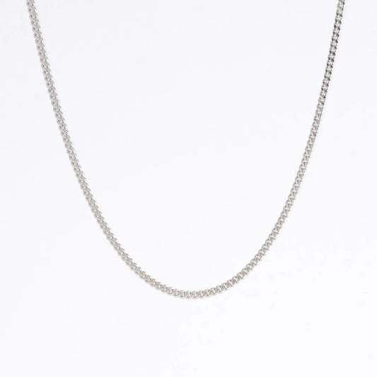 Silver curb chain necklace on a light gray background