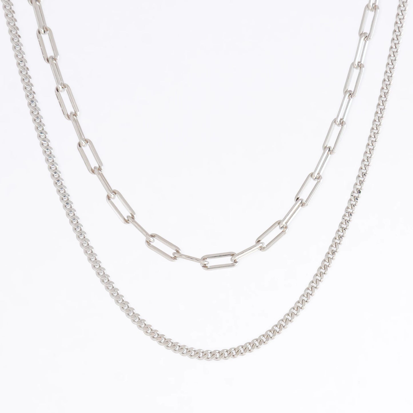 Two silver chain necklaces on a light gray background