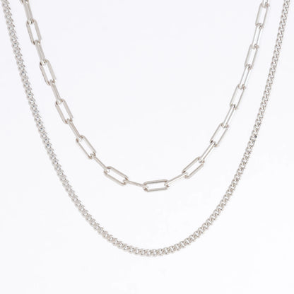 Two silver chain necklaces on a light gray background