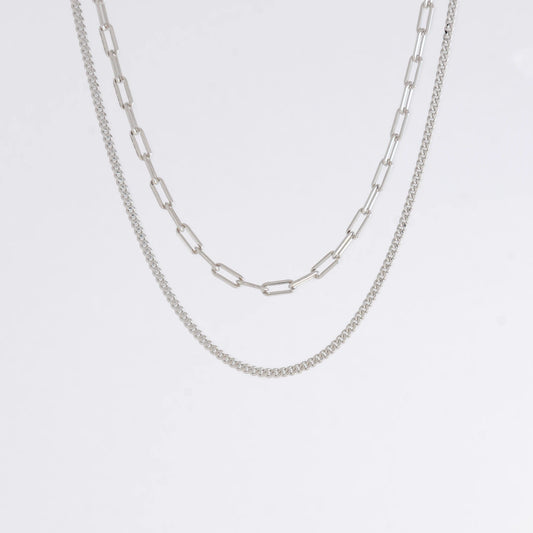 Two silver chain necklaces on a light gray background