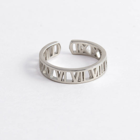 Silver ring with Roman numeral design on a light gray background
