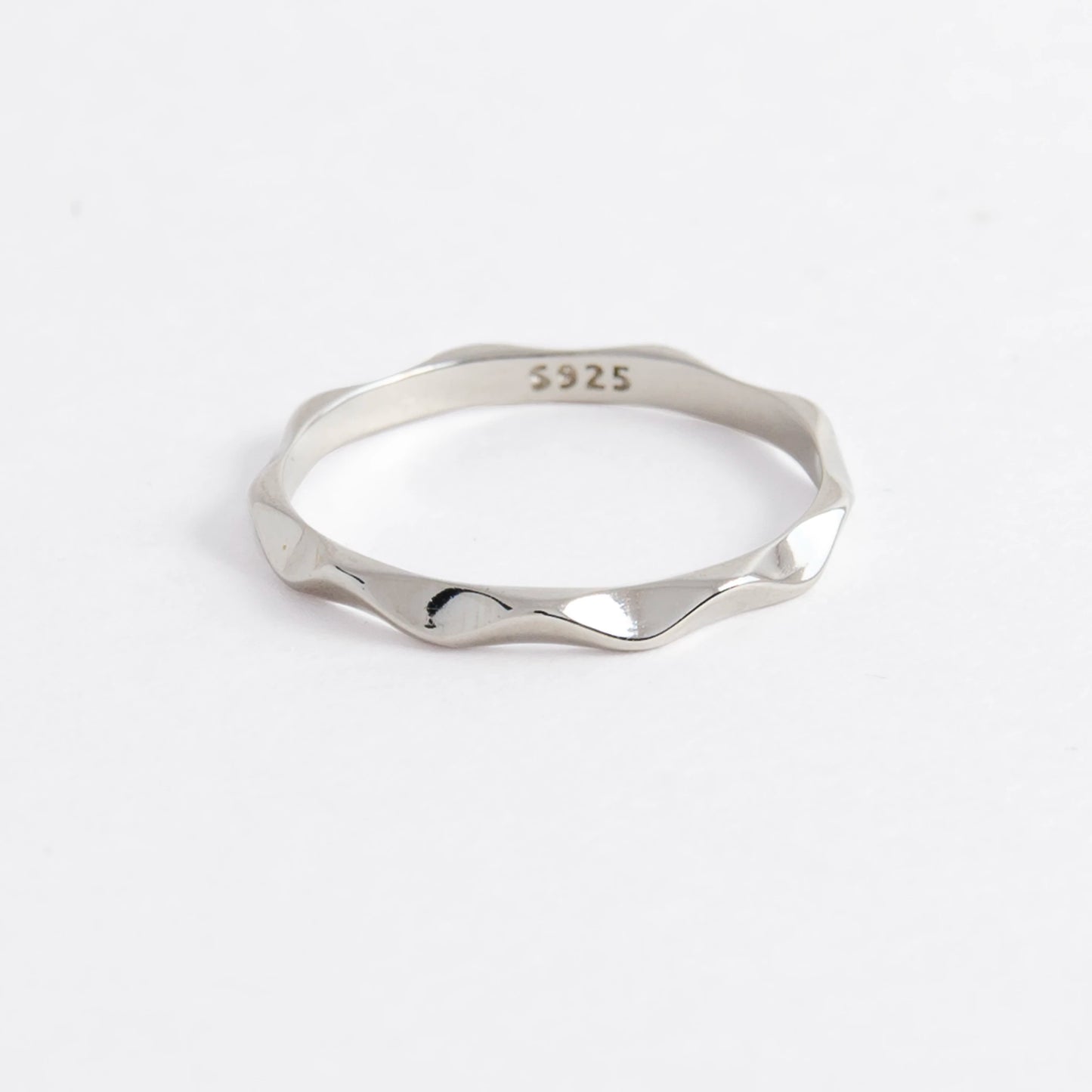 Silver wave ring on a light gray background