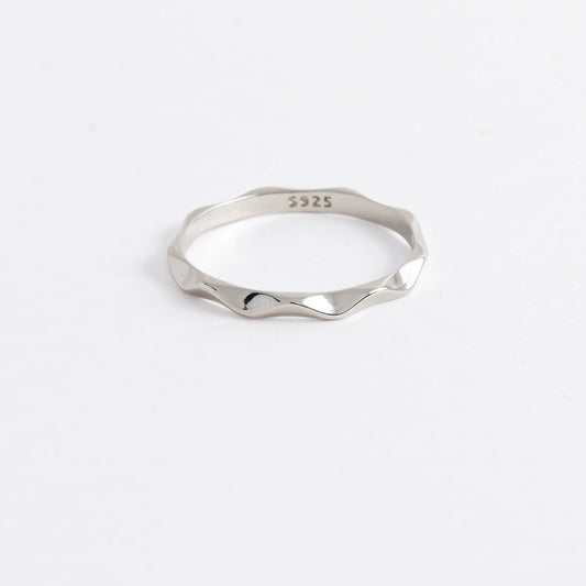 Silver wave ring on a light gray background