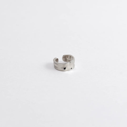 Silver ear cuff on a light gray background