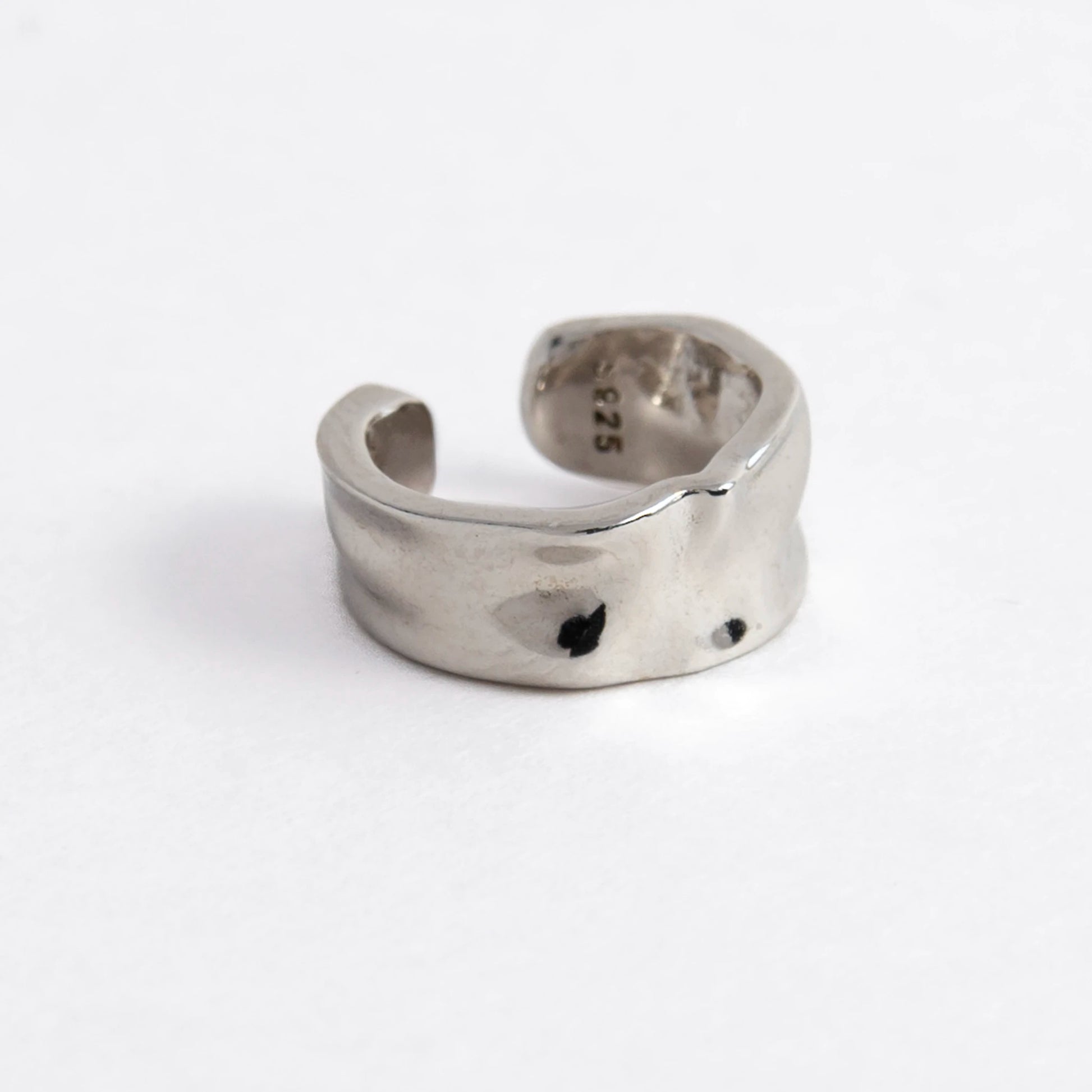 Silver ear cuff on a light gray background