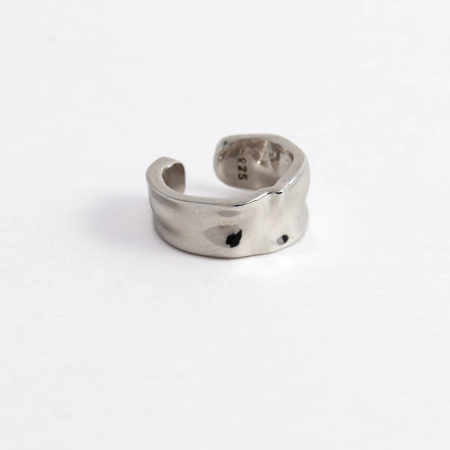 Silver ear cuff on a light gray background