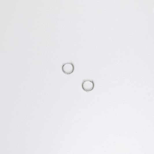Two silver hoop earrings on a light gray background