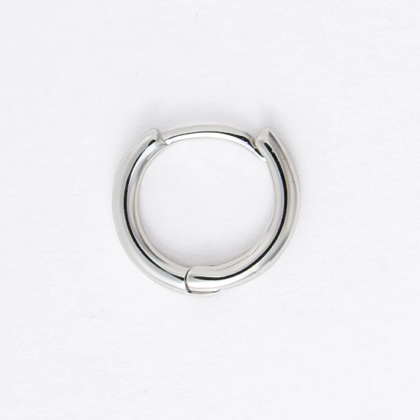 Two silver hoop earrings on a light gray background