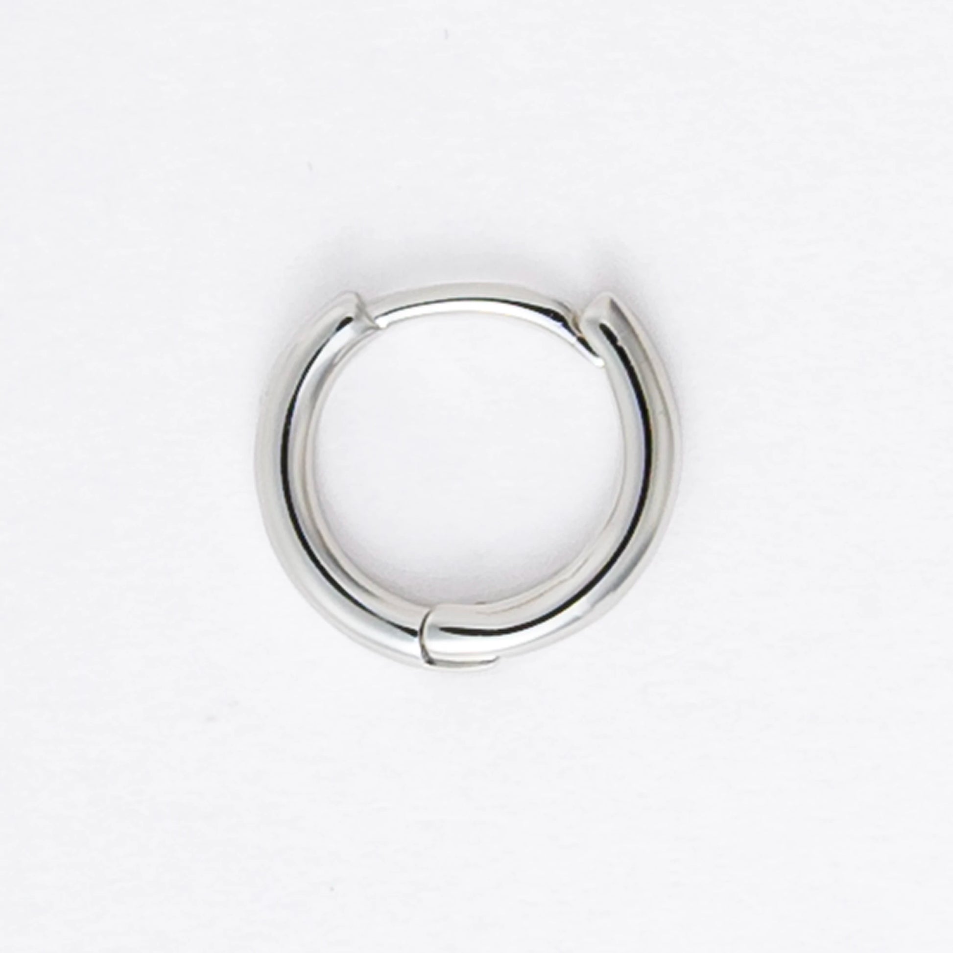 Two silver hoop earrings on a light gray background