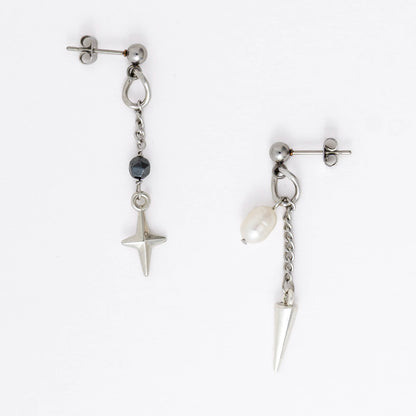 Pair of silver stainless steel ball stud drop earrings with a chain and star charm and a pearl and spike charm on a white background