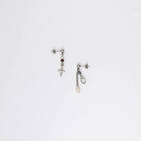 Pair of silver stainless steel ball stud drop earrings with orange and black glass beads and star and pearl charm with unique designs on a white background