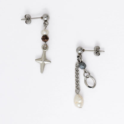 Pair of silver stainless steel ball stud drop earrings with orange and black glass beads and star and pearl charm with unique designs on a white background