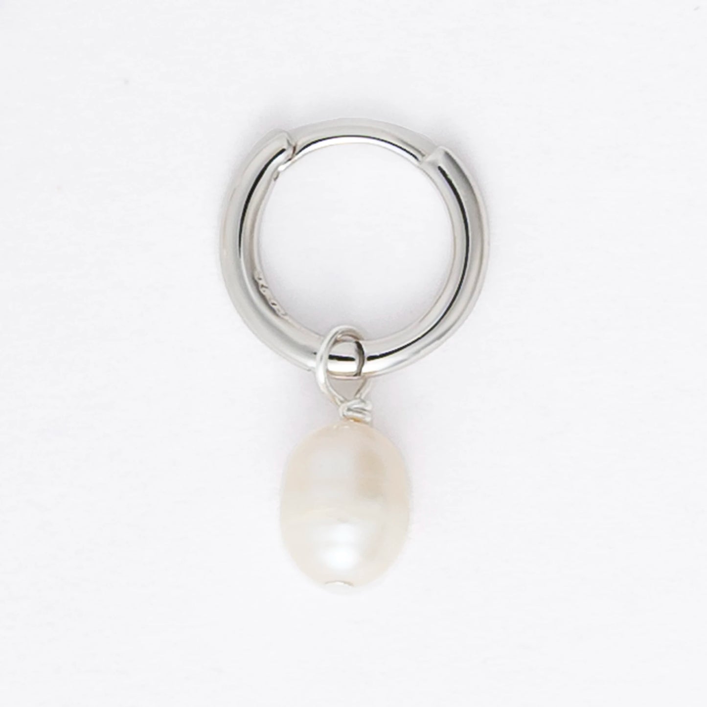 Pair of silver hoop earrings with pearl drops on a light gray background