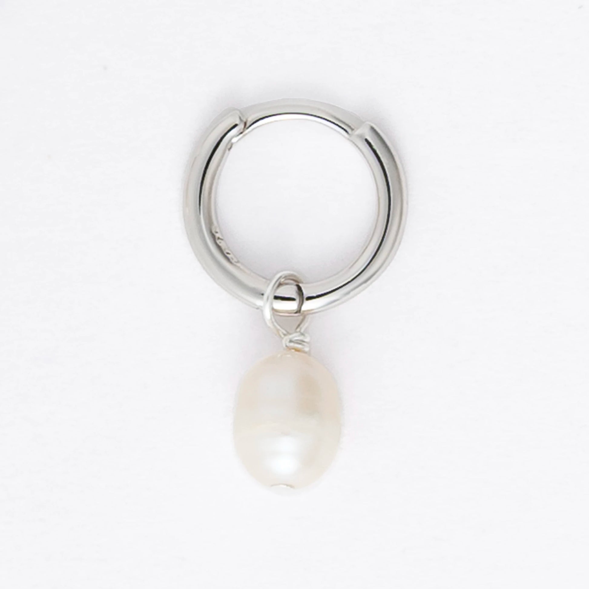 Pair of silver hoop earrings with pearl drops on a light gray background
