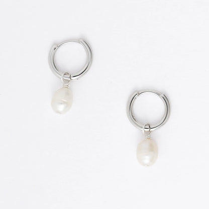 Pair of silver hoop earrings with pearl drops on a light gray background