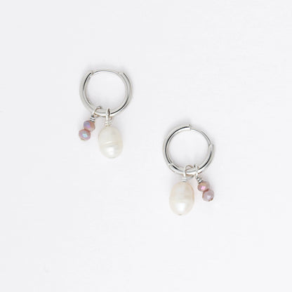 Pair of silver hoop earrings with pearls and a black bead on a white background