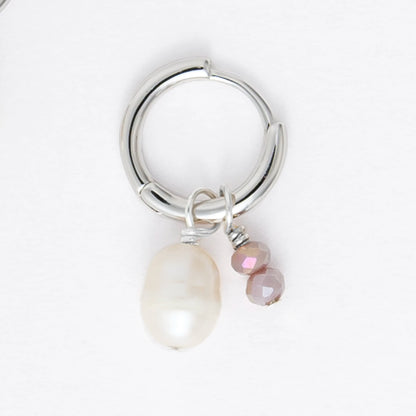 Pair of silver earrings with small pearls on a light gray background
