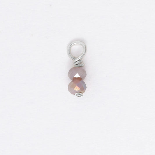 Two small purple glass bead charm on a white background