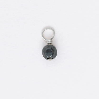 Small black and silver pendant on a white background