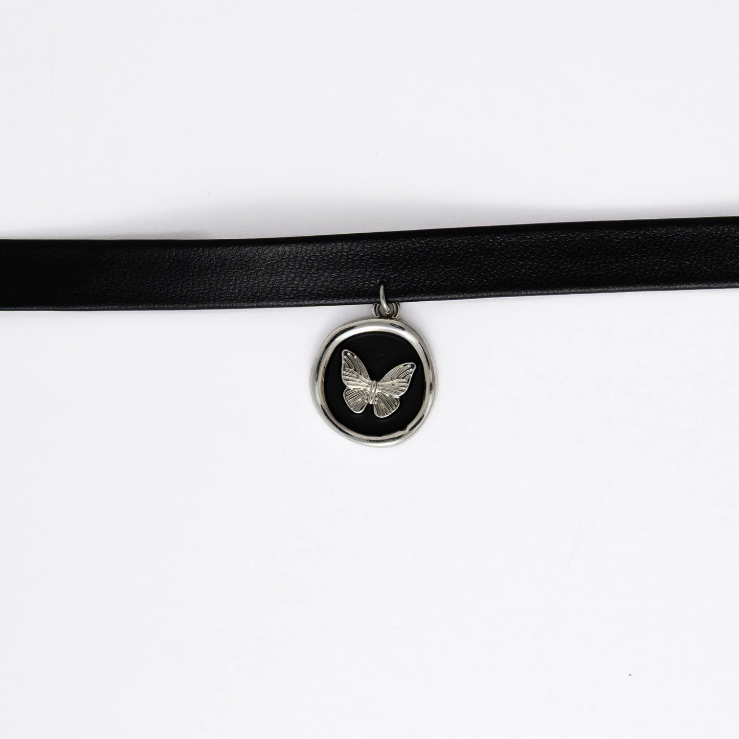 A black leather choker necklace with a central butterfly stamp pendant, displayed against a white background