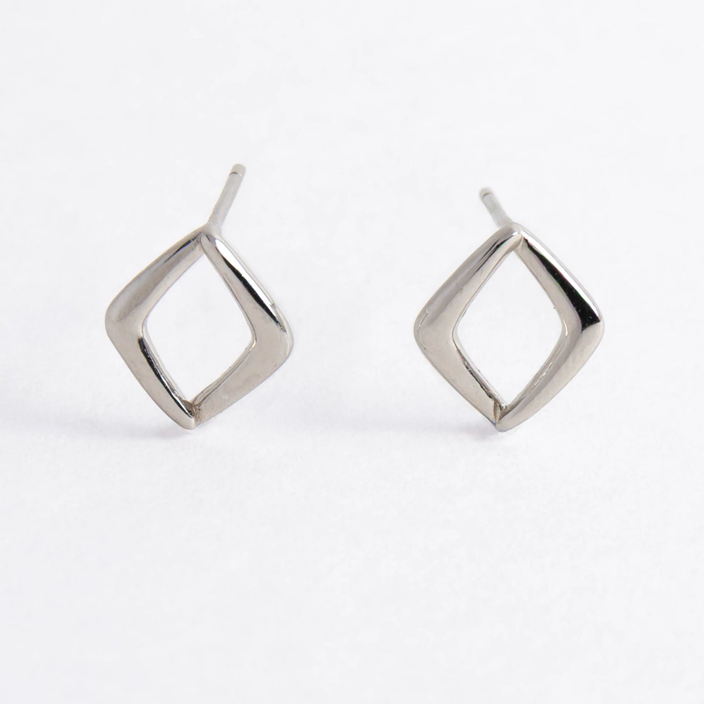 Pair of silver square earrings on a light gray background