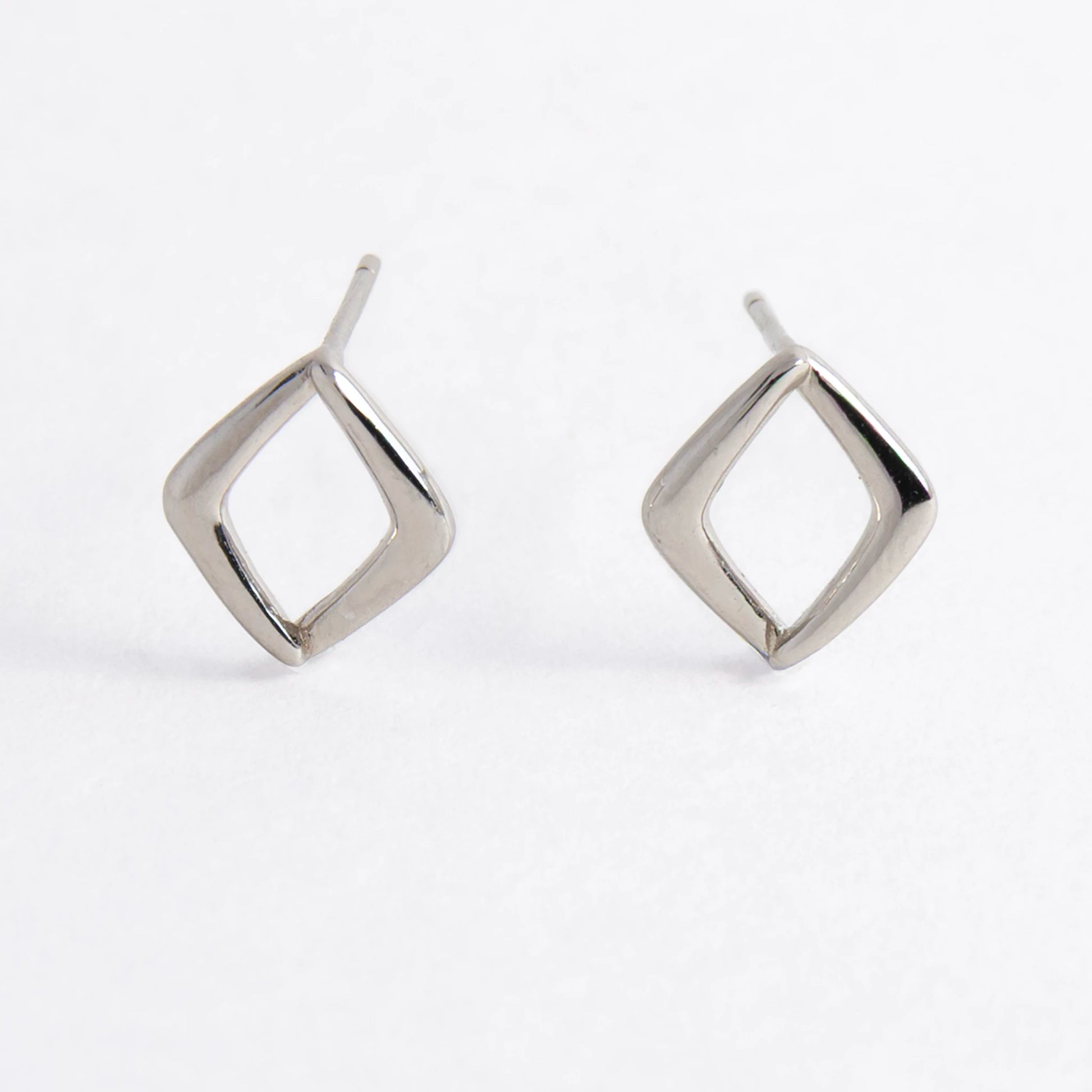 Pair of silver square earrings on a light gray background
