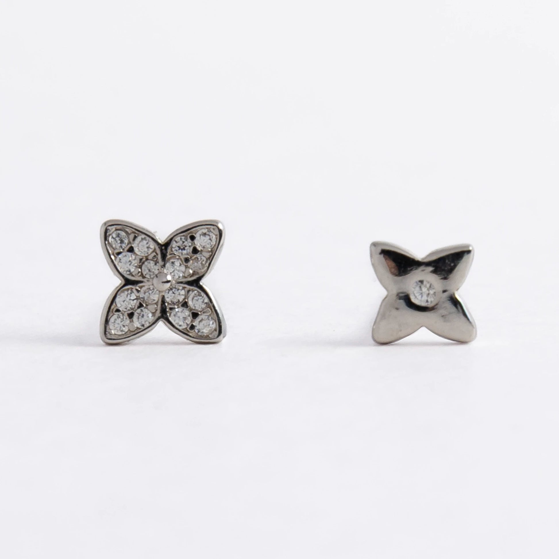 Pair of silver star-shaped earrings on a white background