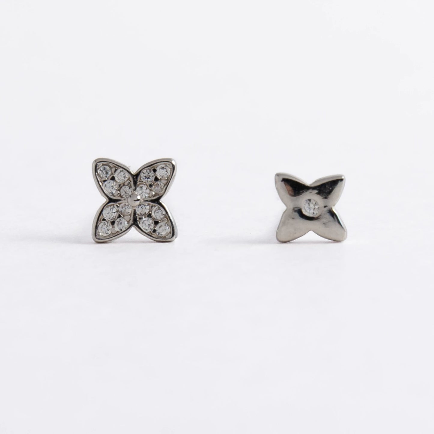 Pair of silver star-shaped earrings on a white background