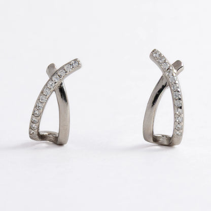 Pair of silver crossed earrings on a light gray background