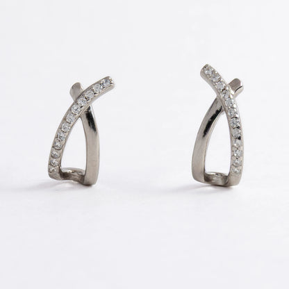 Pair of silver crossed earrings on a light gray background