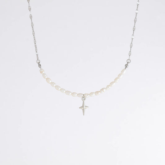 Silver pearl choker necklace with a small north star pendant on a light gray background