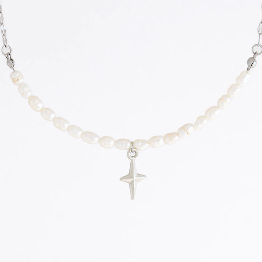 Silver pearl choker necklace with a small north star pendant on a light gray background