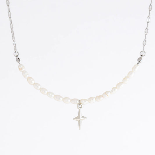 Silver pearl choker necklace with a small north star pendant on a light gray background